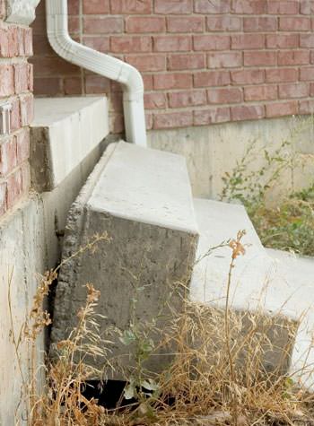 sinking outdoor concrete steps showing cracking and soil washout in Fitchburg