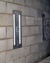 an inside view of foundation wall anchors installed along a basement wall to brace and repair the structure in Sun Prairie