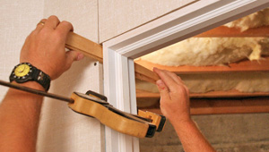 Installing trim and finishing touches to a remodeled basement in Janesville, WI & IL