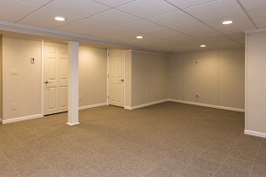 Finished basement space with waterproof wall paneling, ceiling tiles and floor system