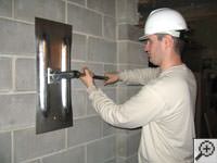 Attempting to straighten a bowed foundation wall by straightening a wall anchor system in a West Allis home.