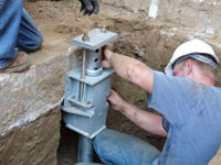 Foundation repair contractors installing the foundation bracket in Rockford, IL.
