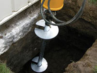 Installing a helical pier system in the earth around a foundation in Kenosha