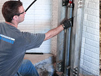 Driving foundation piers into the floor in Beloit.