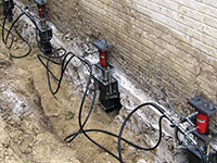 Using foundation push piers to lift a foundation during a repair in La Crosse.