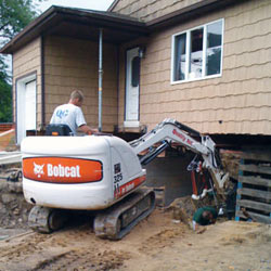 Excavating to expose the foundation walls and footings for a replacement job in Beloit
